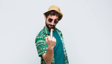 Genç turist kızgın, sinirli, asi ve agresif hissediyor, orta parmağını sallıyor, beyaz duvara karşı savaşıyor.