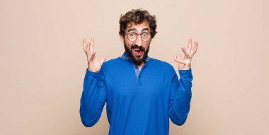 Genç yakışıklı adam ellerini havaya kaldırarak bağırıyor, öfkeli, sinirli, stresli ve üzgün hissediyor.