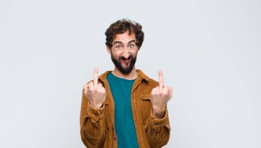 Genç yakışıklı adam kışkırtıcı, agresif ve müstehcen hissediyor. Düz duvara karşı isyankar bir tavırla orta parmağını hareket ettiriyor.