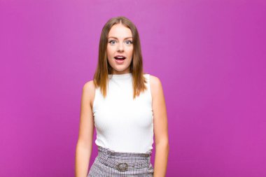 Kızıl saçlı güzel kadın çok şaşırmış ya da şaşkın görünüyor, ağzı açık mor duvara karşı 