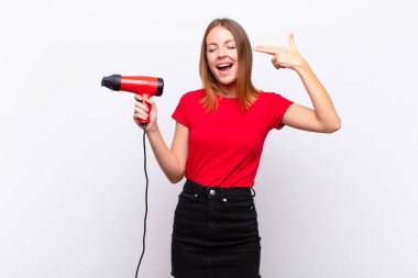 Kızıl saçlı hoş bir kadın mutsuz ve stresli görünüyor, intihar işareti yapıyor, elinde bir kuaför tutan kafayı işaret ediyor.