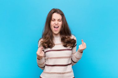 Genç, güzel bir kadın kışkırtıcı, agresif ve müstehcen hissediyor. Mavi duvara karşı isyankar bir tavırla orta parmağını hareket ettiriyor.