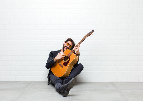 young man playing guitar on the floor