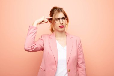 Genç, güzel sarışın kadın kafası karışık ve şaşkın hissediyor. Deli, deli ya da aklını kaçırmış olduğunu gösteriyor. iş kavramı