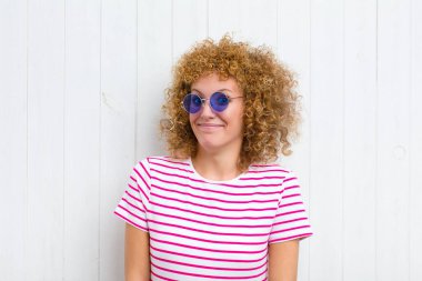 Genç, güzel bir kadın mutlu ve şapşal görünüyor. Geniş, eğlenceli, deli gülüşü ve gözleri açık.