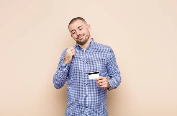 年轻英俊的男人看上去骄傲自满 积极向上 拿着信用卡指着自己 — 图库照片