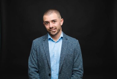 Genç işadamı şaşkın ve şaşkın görünüyor, gergin bir hareketle dudaklarını ısırıyor, düz duvara karşı sorunun cevabını bilmiyor.