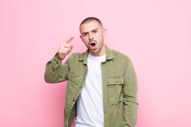 Genç yakışıklı bir adam kızgın agresif bir ifadeyle kameraya bakıyor. Kızgın, çatlak bir patrona benziyor.