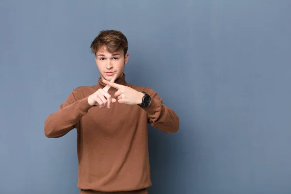 Junger Blonder Mann Der Ernst Und Unzufrieden Mit Beiden Fingern — Stockfoto