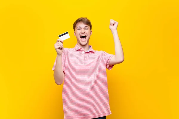 Joven Hombre Rubio Con Una Tarjeta Crédito —  Fotos de Stock