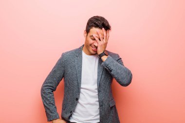 Genç Arap adam gülüyor ve alnına şaplak atıyor. Unutmuşum yoksa pembe duvara karşı yaptığım aptalca bir hataydı. 