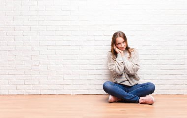 Genç sarışın güzel kız aşık ve sevimli görünüyor. Sevimli ve mutlu. Romantik bir şekilde gülümsüyor.