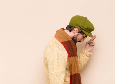 Genç havalı sakallı adam gergin ve umutlu, dua ediyor ve şans diliyor.