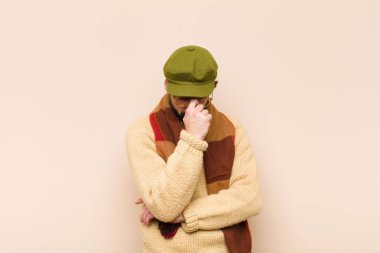 Genç havalı sakallı adam stresli, mutsuz ve hayal kırıklığına uğramış, alınlı ve şiddetli baş ağrısı çeken.