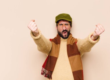 Genç havalı sakallı adam mutlu, pozitif ve başarılı hissediyor, zaferi, başarıları ya da iyi şansı kutluyor.