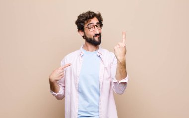 Genç sakallı adam yassı duvara yaslandı.