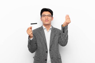 Genç Japon adam sana borcunu ödemeni söyleyerek kapiş ya da para hareketi yapıyor! Kredi kartı kavramı.