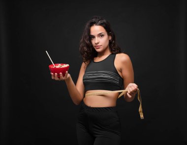 Genç ve güzel bir kadın sağlıklı bir kase yiyor.