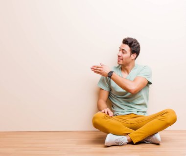 Genç Arap adam gülümsüyor, seni selamlıyor ve başarılı bir anlaşma için el sıkışmayı teklif ediyor.