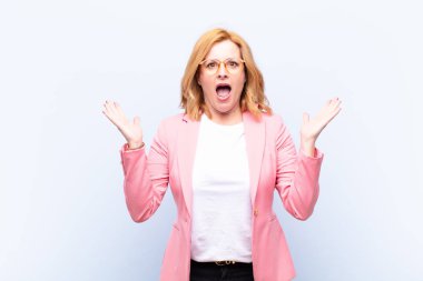 Orta yaşlı bir kadın mutlu, heyecanlı, şaşırmış ya da şaşırmış hissediyor, gülümsüyor ve hayret verici bir şeye şaşırıyor.