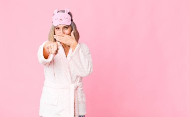 Orta yaşlı bir kadın sana gülüyor, kamerayı gösteriyor ve seninle dalga geçiyor ya da alay ediyor. gece elbisesi konsepti