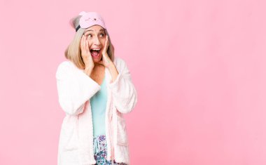 Orta yaşlı bir kadın mutlu, heyecanlı ve şaşırmış hissediyor. İki eli yüzü de havada bir tarafa bakıyor. gece elbisesi konsepti