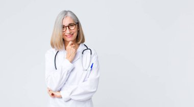 Orta yaşlı doktor kadın gülümsüyor, hayattan zevk alıyor, mutlu, arkadaş canlısı, tatmin olmuş ve tasasız.