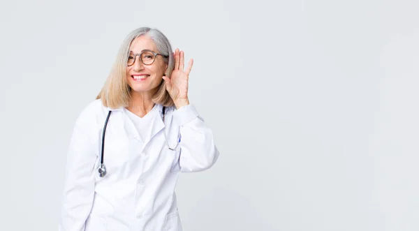 Middelbare Leeftijd Dokter Vrouw Glimlachend Nieuwsgierig Naar Zijkant Proberen Luisteren — Stockfoto