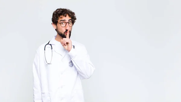 Jovem Médico Homem Olhando Sério Cruz Com Dedo Pressionado Para — Fotografia de Stock