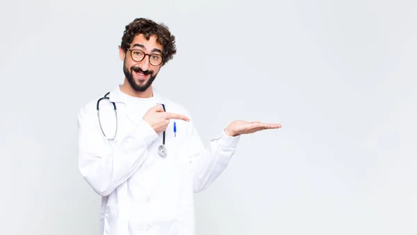의사는 명랑하게 웃으면서 손바닥 공간을 가리키면서 반대되는 물체를 주거나 광고하였다 — 스톡 사진