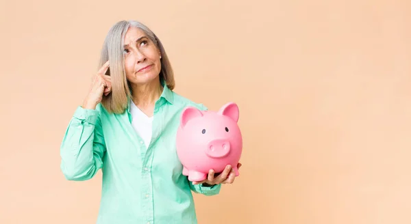 Middelbare Leeftijd Mooie Vrouw Houden Een Spaarvarken Bank Tegen Kopieerruimte — Stockfoto