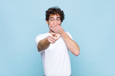 Genç çılgın sakallı adam sana gülüyor, kamerayı gösteriyor ve seninle dalga geçiyor ya da düz duvara karşı alay ediyor.