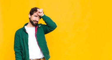 Genç, çılgın, sakallı, stresli, yorgun ve hayal kırıklığına uğramış görünen alnından ter damlayan, umutsuz ve bitkin hisseden bir adam.