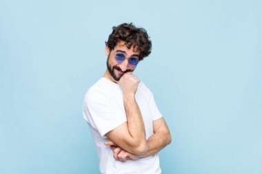 Genç çılgın sakallı adam güneş gözlüğü takıyor.