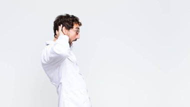 Genç çılgın sakallı doktor, fotokopi duvarına yaslanmış.