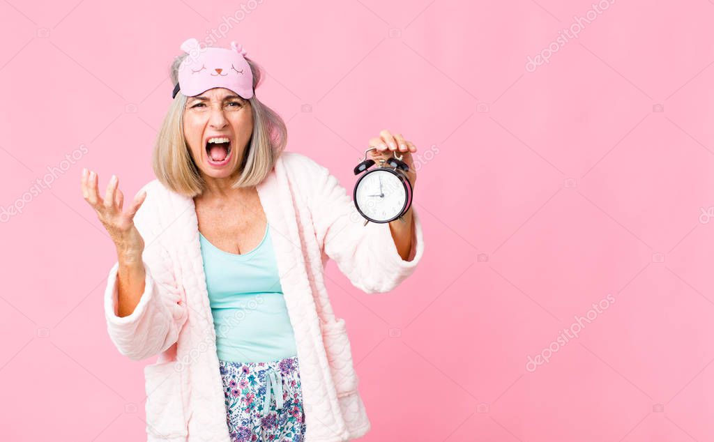 middle age woman wearing night suit with an alarm clock