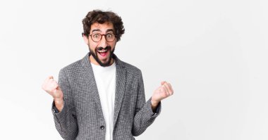 Genç çılgın iş adamı şok olmuş, heyecanlı ve mutlu hissediyor, gülüyor ve başarıyı kutluyor, vay canına! yassı duvara karşı