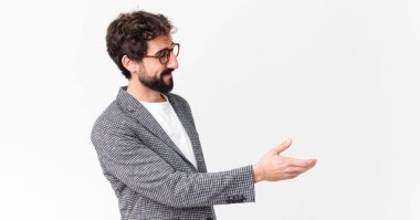 Genç çılgın işadamı gülümsüyor, sizi selamlıyor ve başarılı bir anlaşma için el sıkışmayı teklif ediyor.