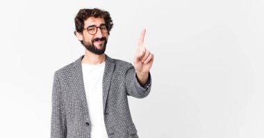 Genç çılgın işadamı gülümsüyor ve arkadaş canlısı görünüyor. Bir numara ya da ilk eli önde, düz duvara doğru sayıyor.