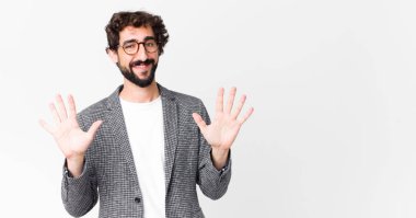 Genç çılgın işadamı gülümsüyor ve arkadaş canlısı görünüyor, onuncu ya da onuncu numarayı gösteriyor, düz duvara doğru sayıyor.