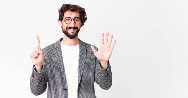 Genç çılgın işadamı gülümsüyor ve arkadaş canlısı görünüyor. Altı ya da altıncı numarayı gösteriyor. Elleri önde, düz duvara doğru sayıyor.