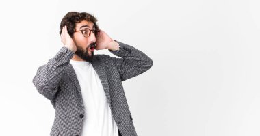 Korkunç bir hata yüzünden dehşete düşmüş ve şok olmuş görünen ağzı açık genç çılgın iş adamı, düz duvara karşı el kaldırıyor.