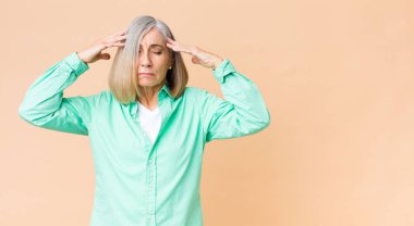 Orta yaşlı, havalı bir kadın. Yoğunlaşmış, düşünceli ve ilham verici görünüyor. Beyin fırtınası yapıyor ve hayal kuruyor.