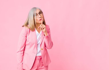 Orta yaşlı, havalı bir kadın sessizlik ve sessizlik istiyor. Parmağını ağzının önüne uzatıp 