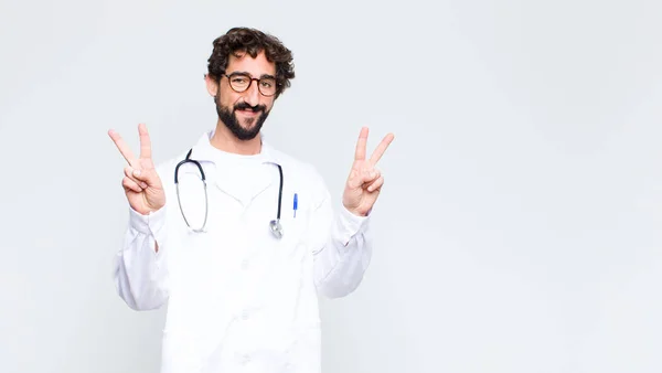 Joven Médico Sonriendo Mirando Feliz Amable Satisfecho Haciendo Gesto Victoria —  Fotos de Stock