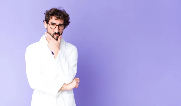 Young Bearded Man Wearing Bathrobe Looking Serious Thoughtful Distrustful One — Stock Photo, Image