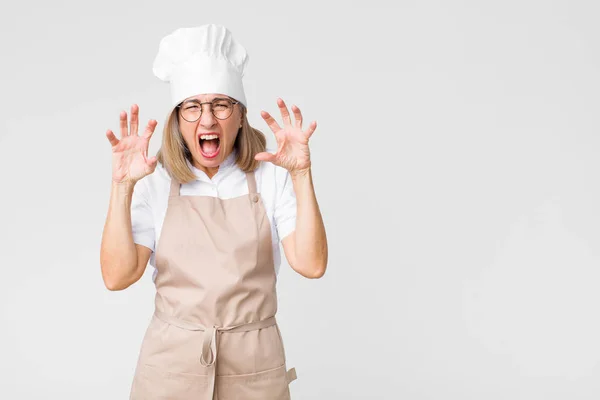 Kobieta Piekarz Średnim Wieku Krzyczy Panice Lub Gniewie Wstrząśnięty Przerażony — Zdjęcie stockowe