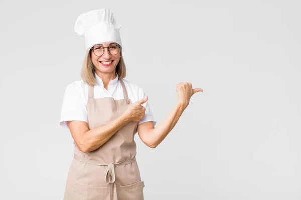 Bäckerfrau Mittleren Alters Lächelt Fröhlich Und Zeigt Beiläufig Auf Den — Stockfoto