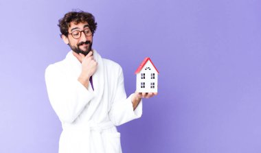 Genç çılgın sakallı adam bornozlu ev konsepti giyiyor