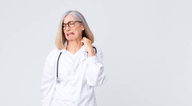 Orta yaşlı kadın stresli, hayal kırıklığına uğramış ve yorgun hissediyordu. Endişeli ve sorunlu bir bakışla boynunu ovuyordu.